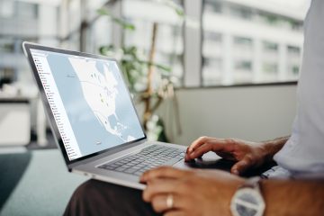 Man sitting with a laptop on his lap looking at a screen with NordVPN on it