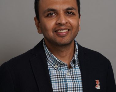 Srikrishnan Ganesan headshot in a checked shirt and suit